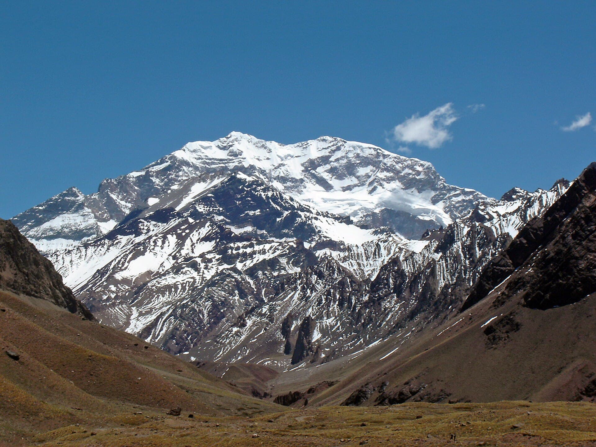 The snow face of Aconcagua above bare moraine