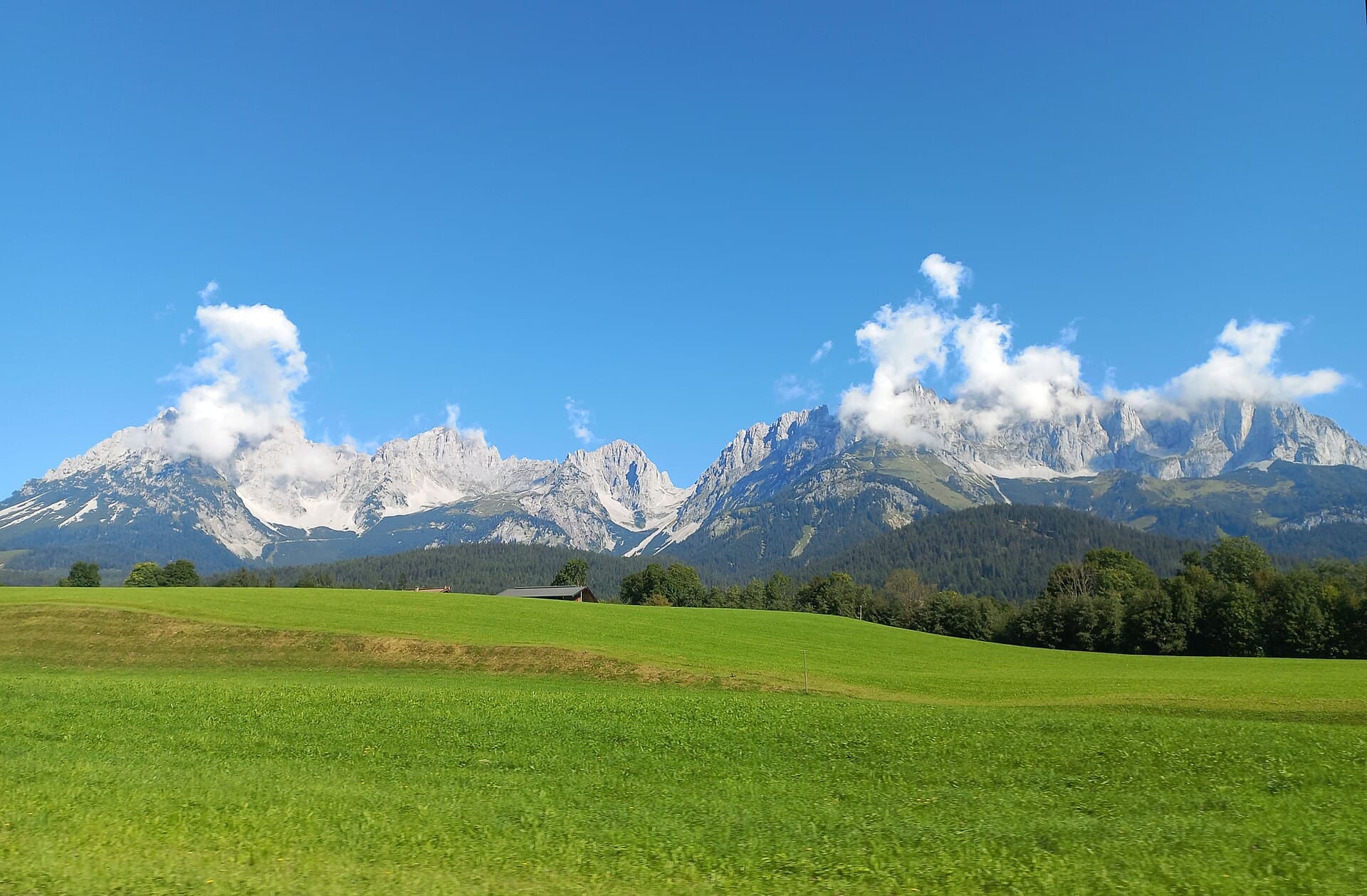 The limestone wall of the Wilder Kaiser above open pasture