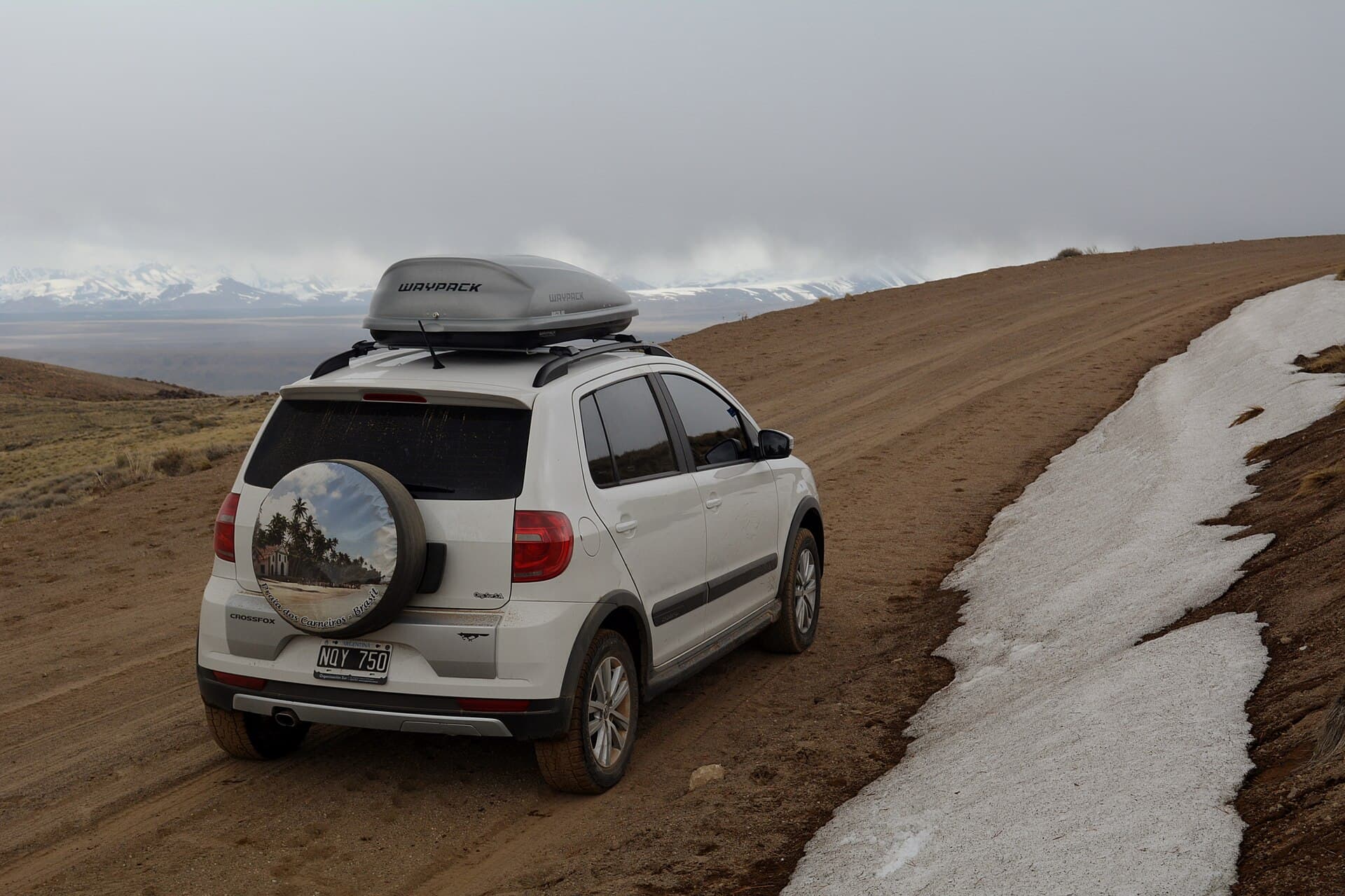 El camino de ripio a las termas del Domuyo con nieve en la banquina